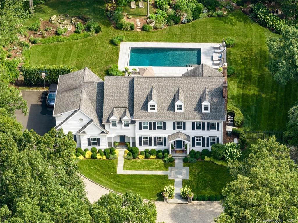an aerial view of a house with a garden and lake view