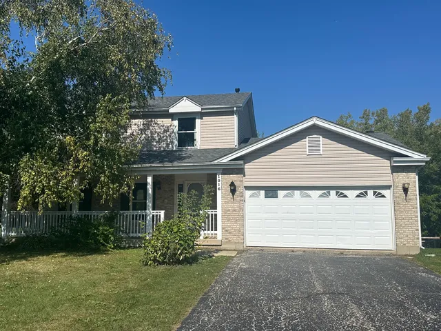a front view of a house with a garden and yard