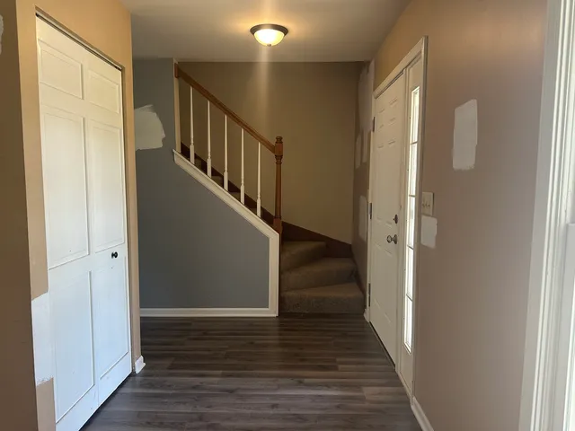 a view of a hallway with wooden floor and staircase