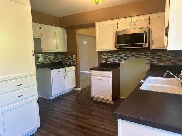 a kitchen with stainless steel appliances a stove a microwave a sink and cabinets