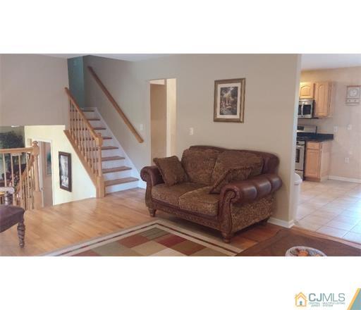 434 Plainfield Road Edison, NJ 08820 - Photo 9 of 16 a living room with couches and a dining table with wooden floor