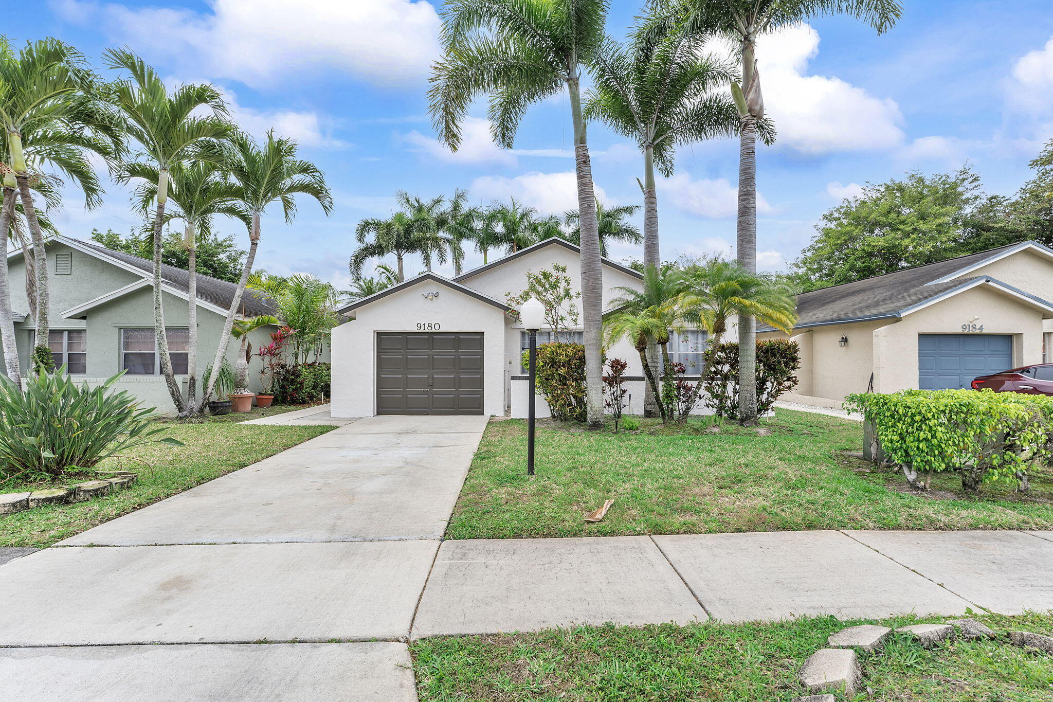 9180 Pine Springs Drive Boca Raton, FL 33428 - Photo 2 of 29 a front view of a house with garden