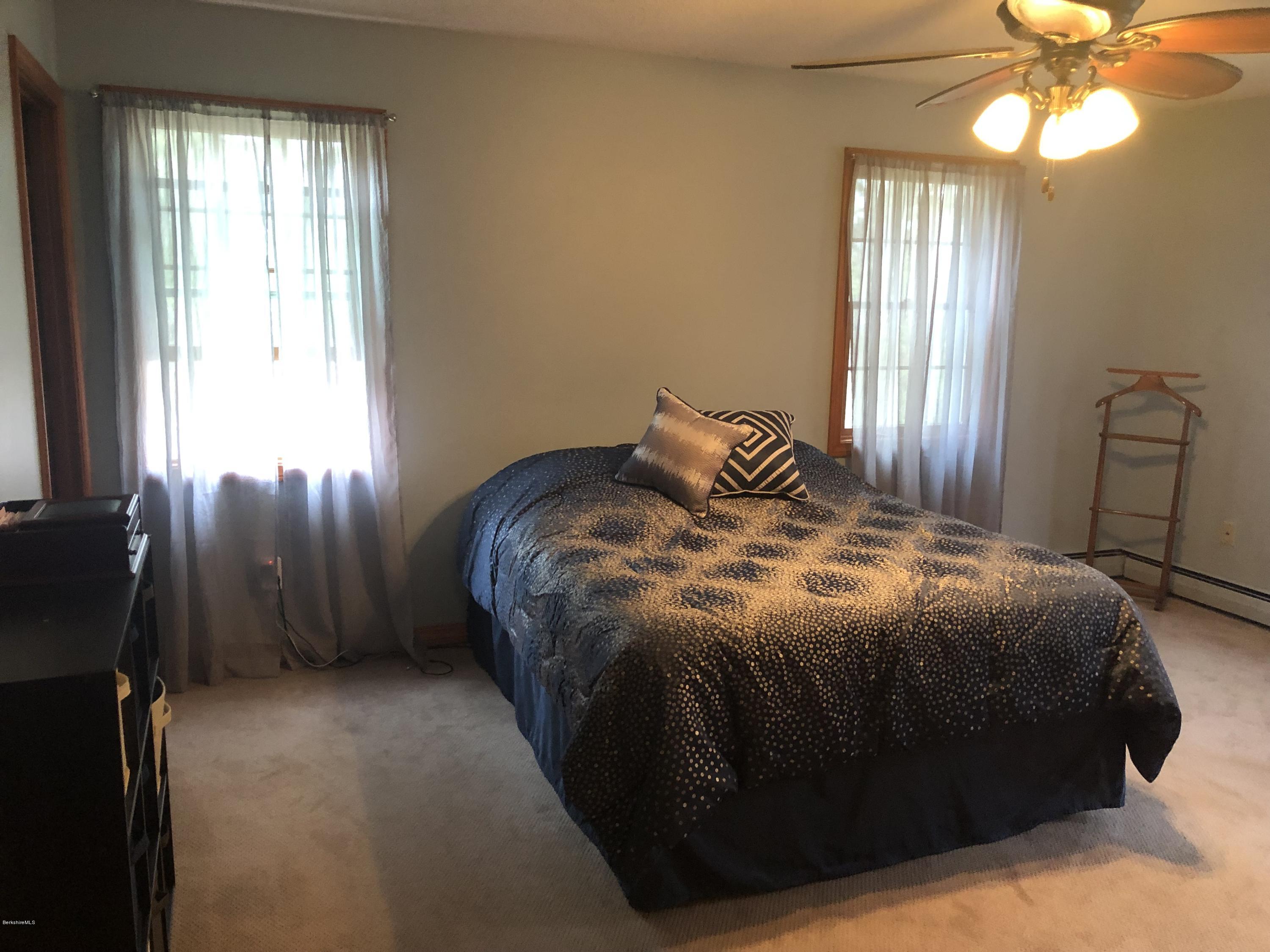 99 Middlefield Road Peru, MA 01235 - Photo 24 of 54 a bedroom with a bed and a chandelier