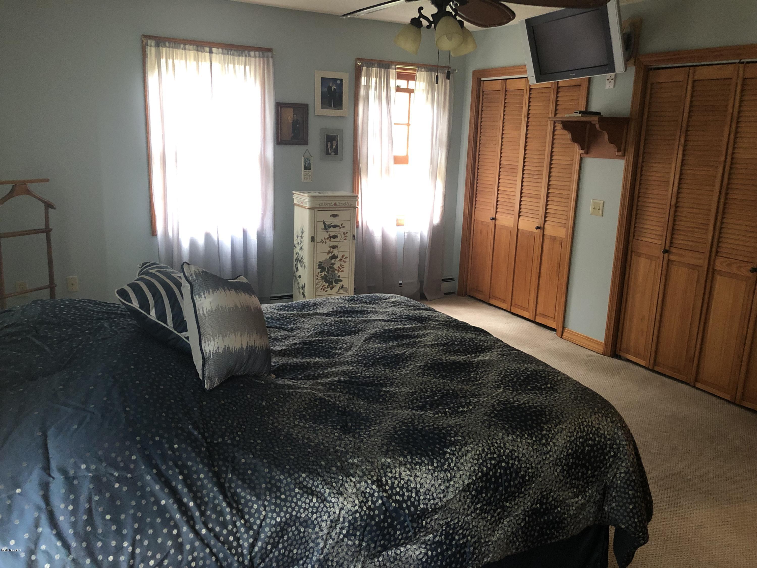 99 Middlefield Road Peru, MA 01235 - Photo 26 of 54 a bed sitting in a bedroom next to a window