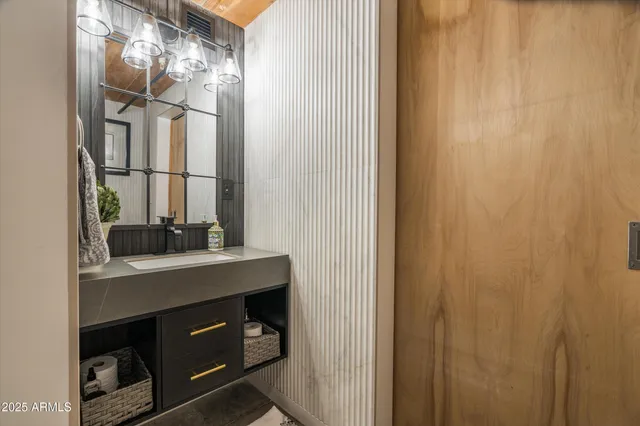 a dining room with wooden floor a chandelier a glass table and chairs