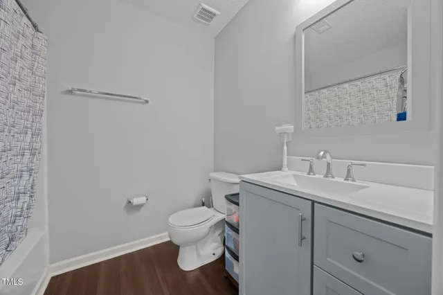 a bathroom with a granite countertop toilet and sink