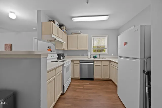 a kitchen with a sink cabinets stainless steel appliances and a window