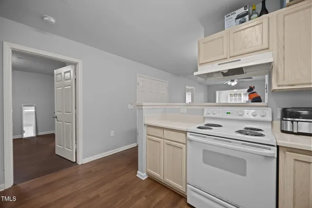 a kitchen with cabinets wooden floor and appliances