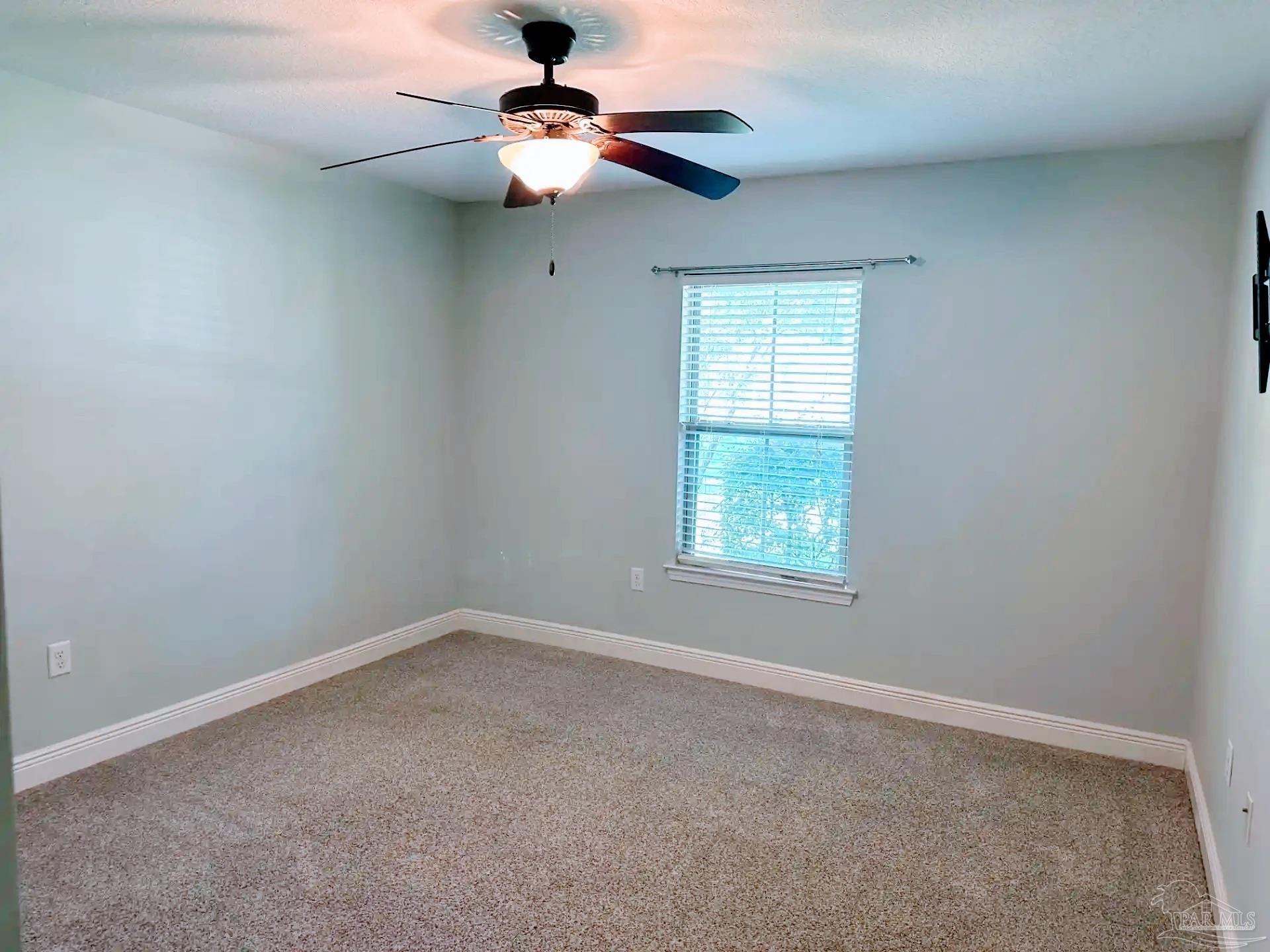 1938 Commodore Drive Navarre, FL 32566 - Photo 19 of 24 an empty room with a window and a fan