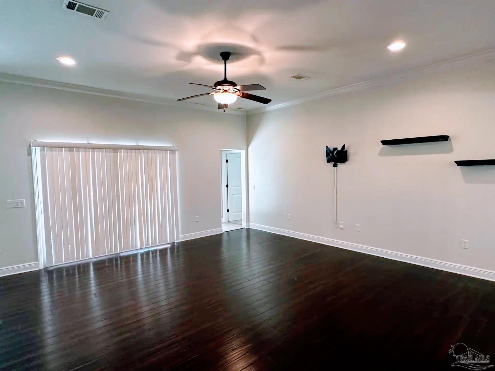 1938 Commodore Drive Navarre, FL 32566 - Photo 5 of 24 an empty room with wooden floor chandelier fan and windows