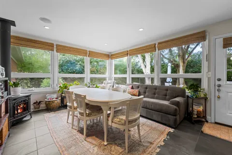 a dining room with furniture and a floor to ceiling window