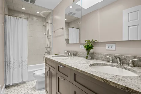 a bathroom with a granite countertop sink a toilet and a shower