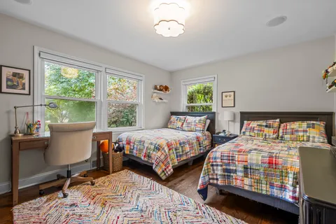 a bedroom with two beds and a large window