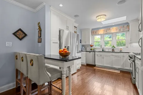 a kitchen with a table chairs refrigerator and window