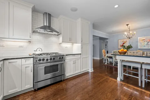 a kitchen with a stove and wooden floor