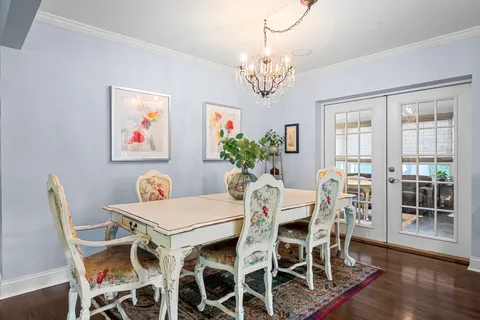 a view of a dining room with furniture a chandelier and wooden floor