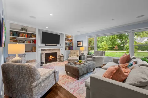 a living room with furniture fireplace and a large window