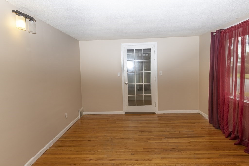 35 Anne Street Springfield, MA 01104 - Photo 8 of 28 a view of an empty room with wooden floor and a window