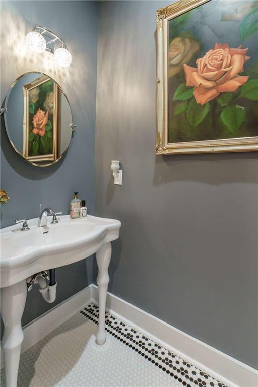 1953-1 Barton Brg Road Madison, GA 30650 - Photo 30 of 78 a bathroom with a sink a mirror and a painting on the wall