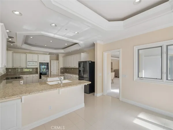 a kitchen with kitchen island granite countertop a stove a table and chairs in it