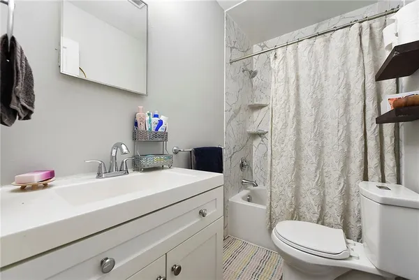 a bathroom with a sink a toilet and shower curtain