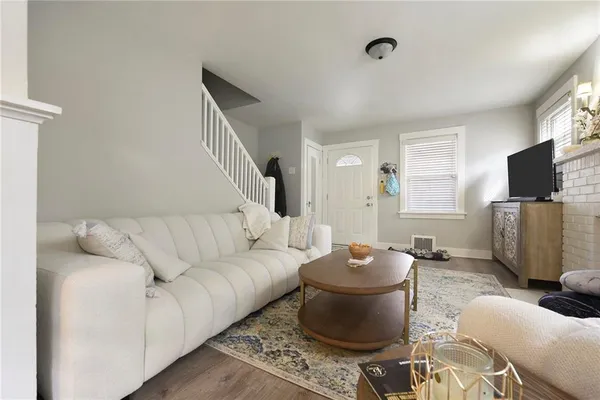 a living room with furniture a flat screen tv and kitchen view