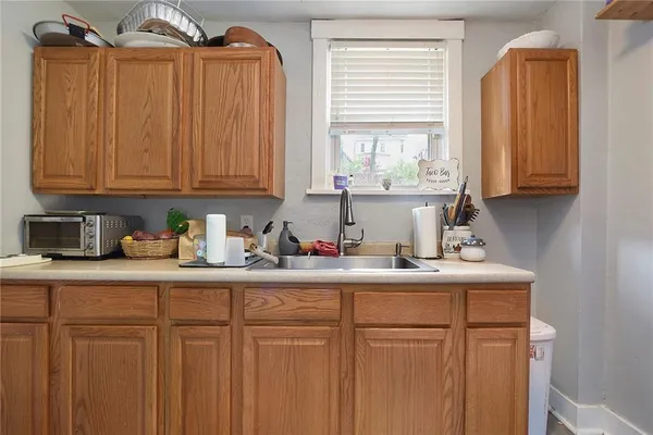 a kitchen with stainless steel appliances granite countertop a sink a window and white cabinets