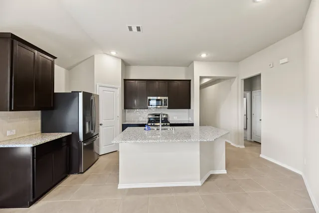 a kitchen with stainless steel appliances a refrigerator and a stove