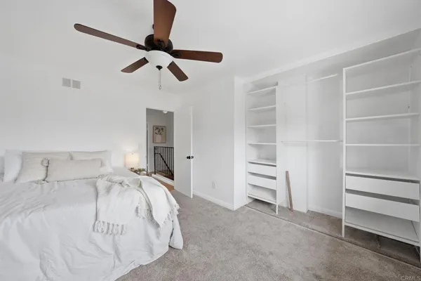 a bedroom with a bed and a ceiling fan