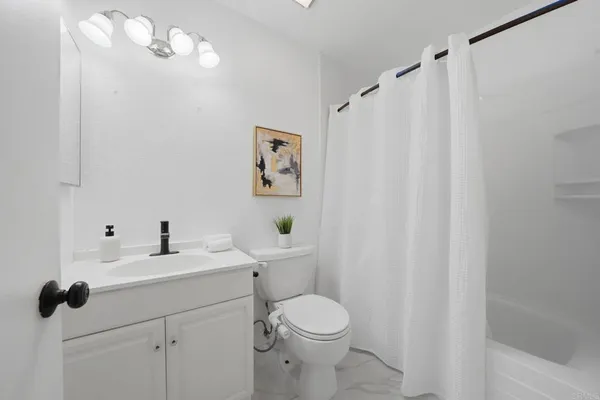a bathroom with a sink a toilet and shower curtain