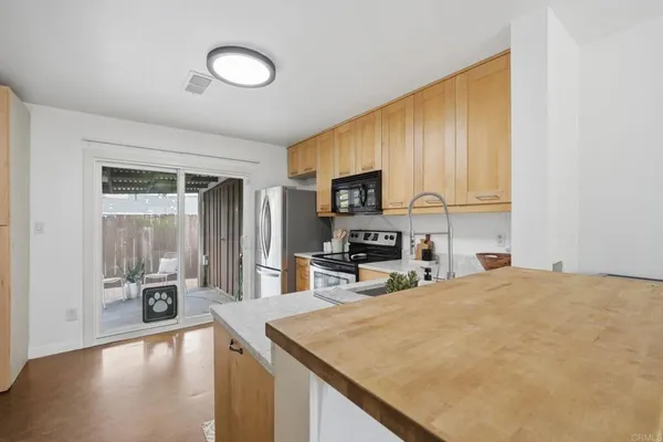 a kitchen with a sink a counter top space appliances and cabinets