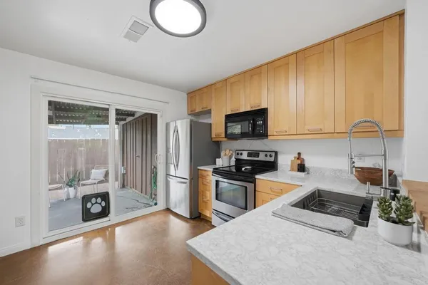 a kitchen with stainless steel appliances granite countertop a stove a sink dishwasher a microwave oven with cabinets and wooden floor