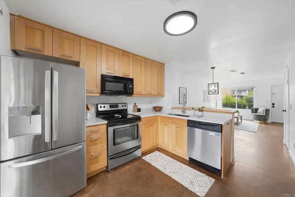 a kitchen with stainless steel appliances granite countertop a stove a sink and a refrigerator