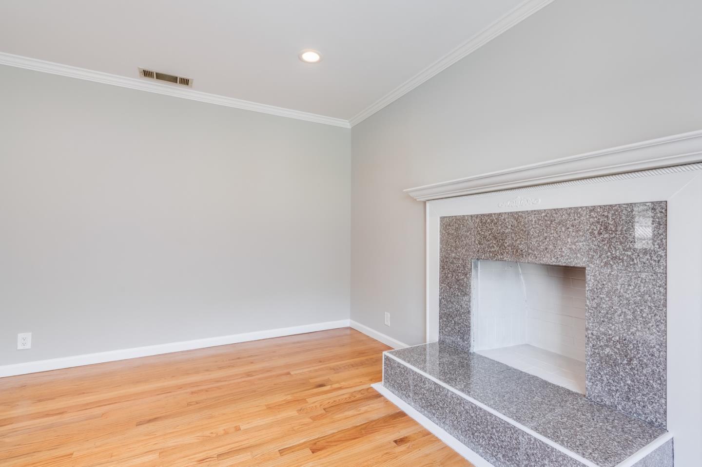 1419 Madeira Drive Pacifica, CA 94044 - Photo 21 of 66 a view of an empty room with wooden floor and a fireplace