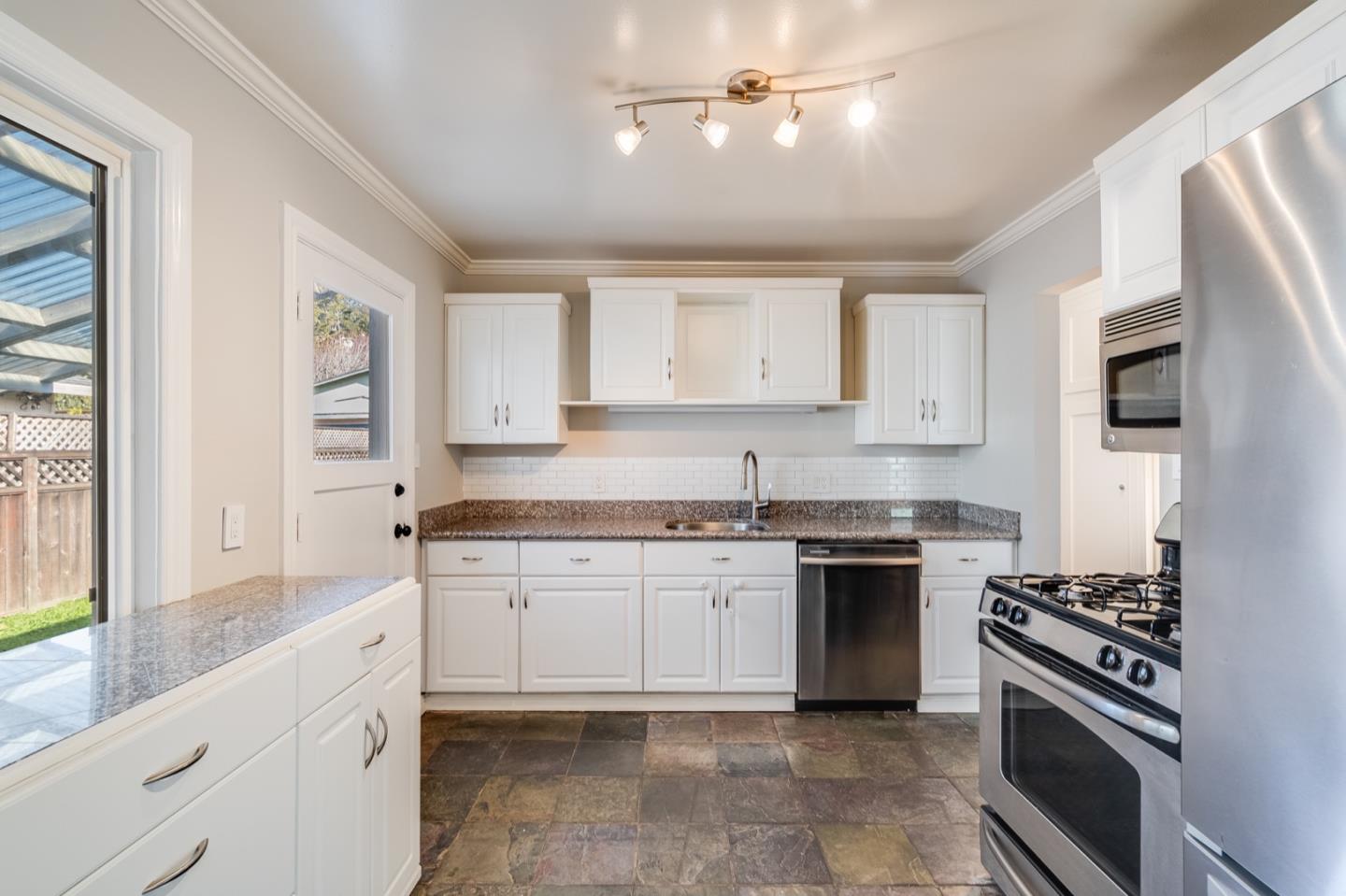 1419 Madeira Drive Pacifica, CA 94044 - Photo 22 of 66 a kitchen with stainless steel appliances granite countertop a stove and a sink