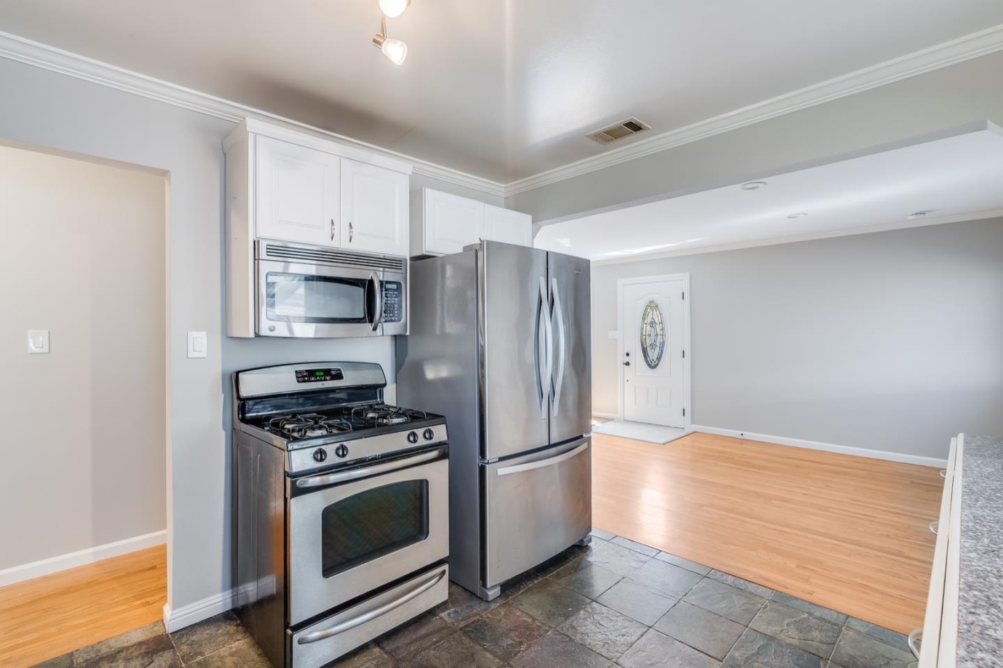1419 Madeira Drive Pacifica, CA 94044 - Photo 25 of 66 a kitchen with stainless steel appliances a stove a microwave and a refrigerator
