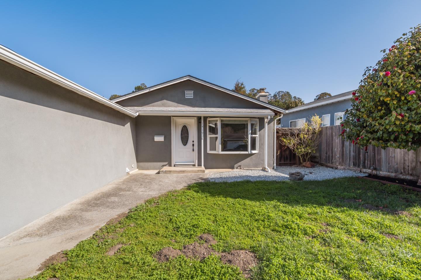 1419 Madeira Drive Pacifica, CA 94044 - Photo 4 of 66 a front view of a house with a yard and garage