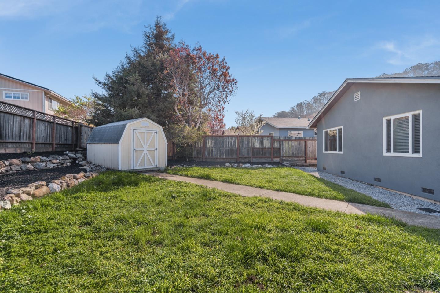 1419 Madeira Drive Pacifica, CA 94044 - Photo 42 of 66 a view of a backyard with table and chairs and wooden fence