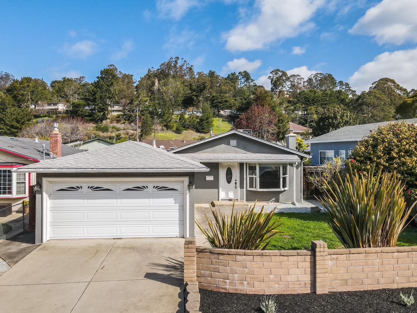 1419 Madeira Drive Pacifica, CA 94044 - Photo 59 of 66 a front view of a house with a yard and garage