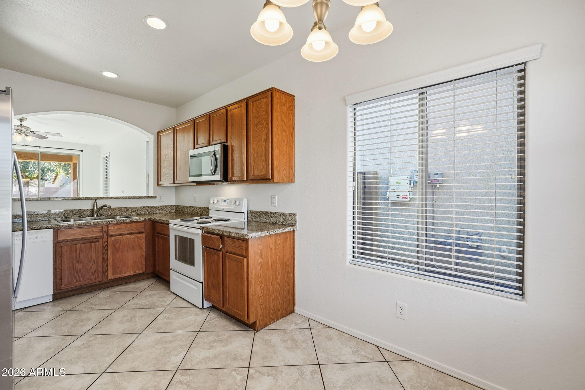 8851 West Payson Road Tolleson, AZ 85353 - Photo 10 of 32 a kitchen with stainless steel appliances granite countertop a stove a sink and a microwave