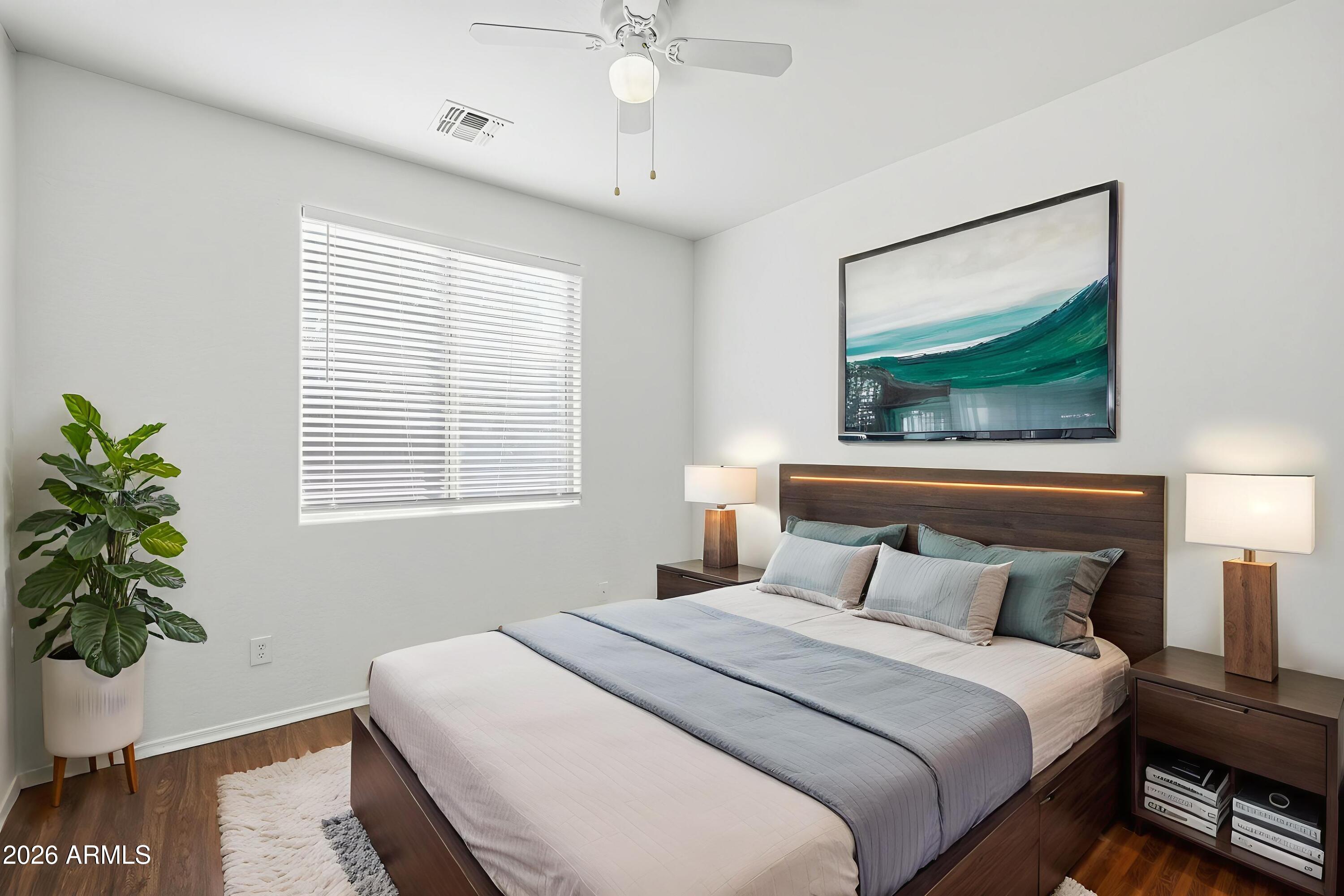 8851 West Payson Road Tolleson, AZ 85353 - Photo 13 of 32 a bedroom with a bed a dresser and a potted plant