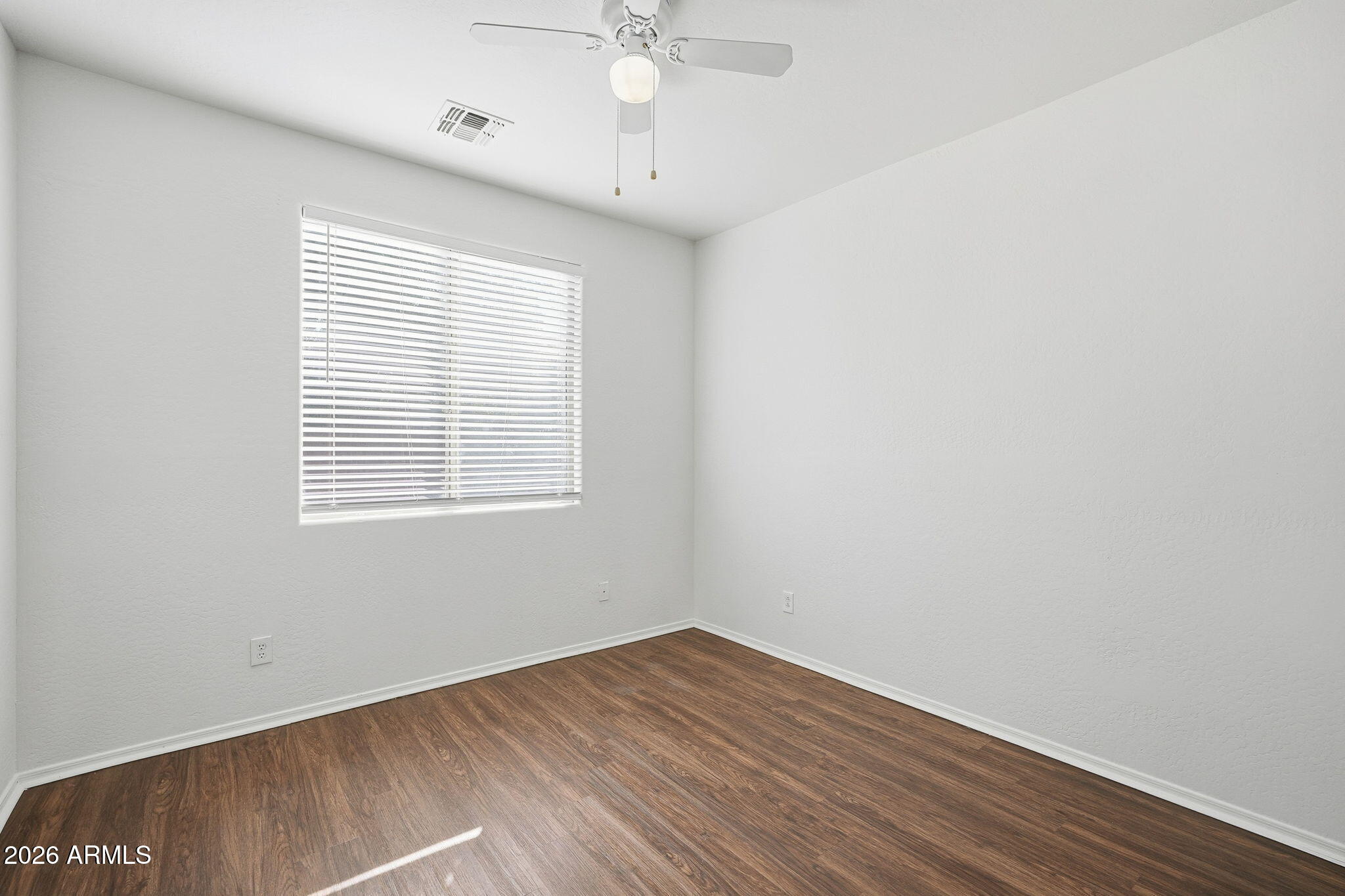 8851 West Payson Road Tolleson, AZ 85353 - Photo 14 of 32 wooden floor in an empty room with a window