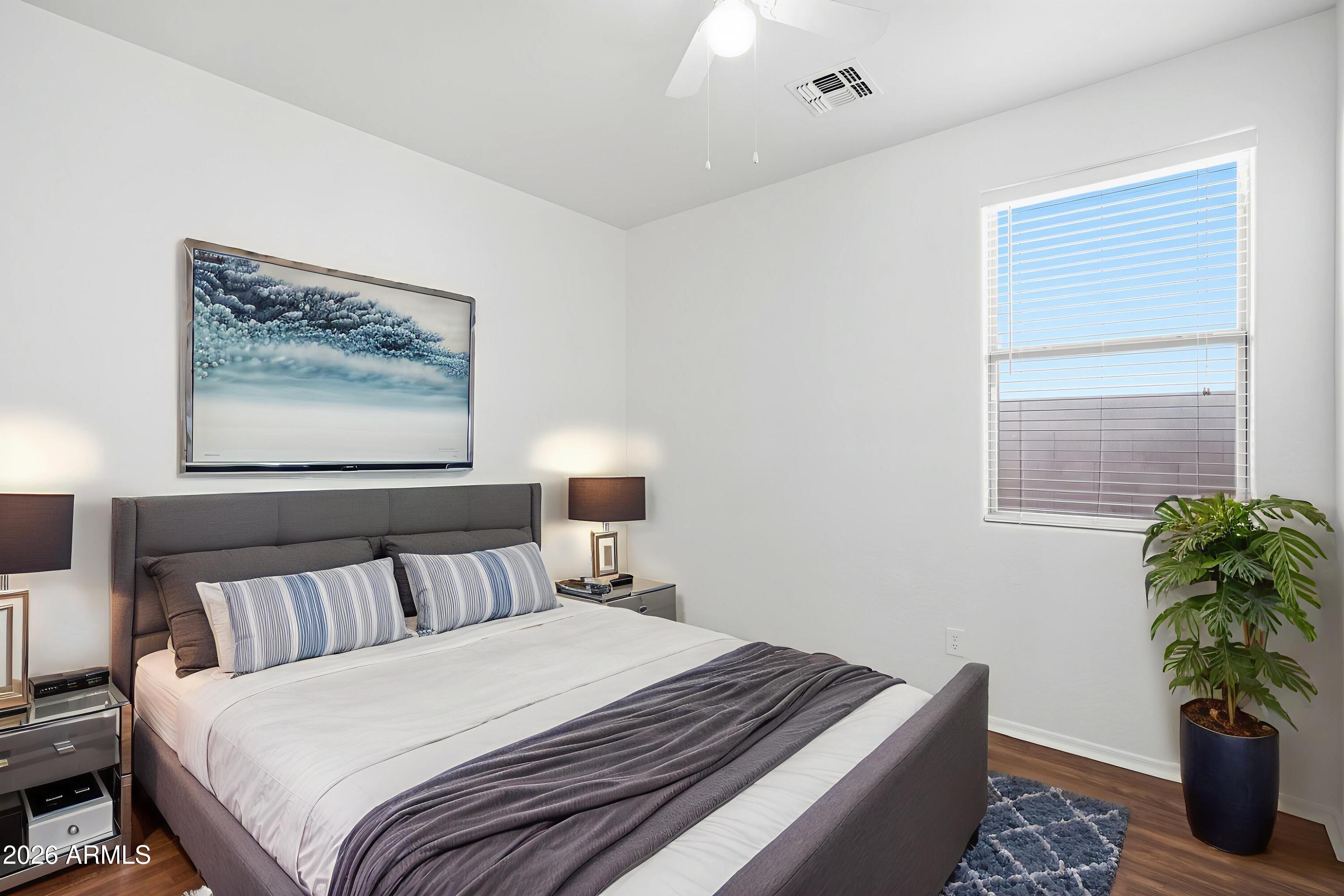 8851 West Payson Road Tolleson, AZ 85353 - Photo 16 of 32 a bedroom with bed and a potted plant