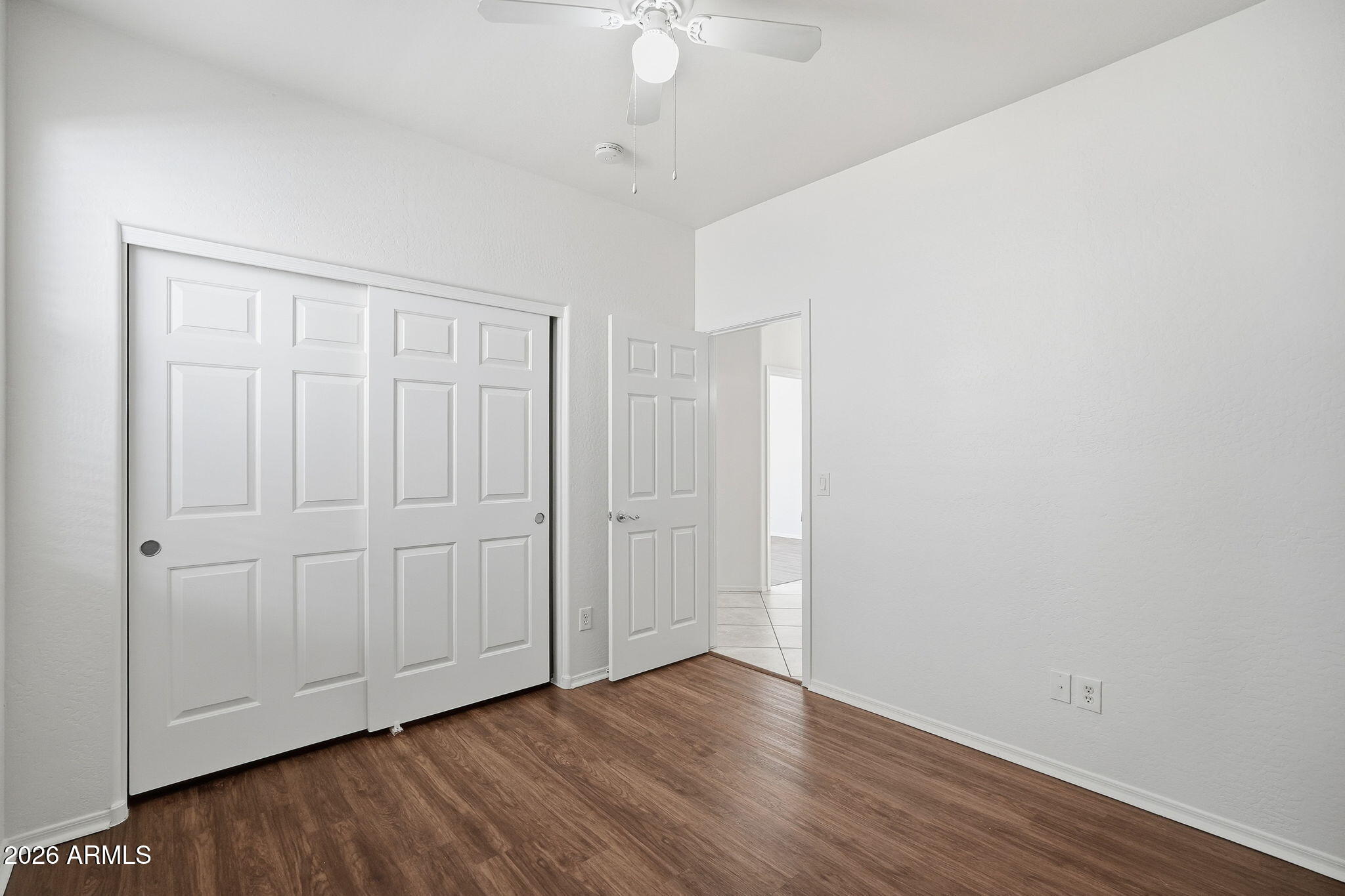 8851 West Payson Road Tolleson, AZ 85353 - Photo 18 of 32 a view of an empty room with wooden floor
