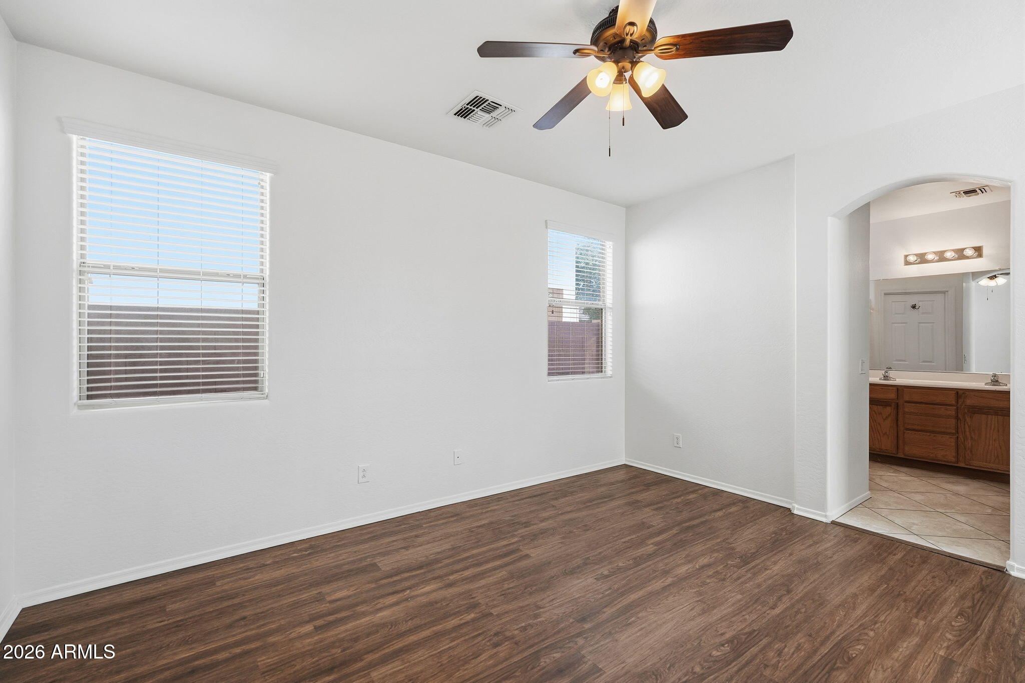 8851 West Payson Road Tolleson, AZ 85353 - Photo 19 of 32 a view of empty room with wooden floor and fan