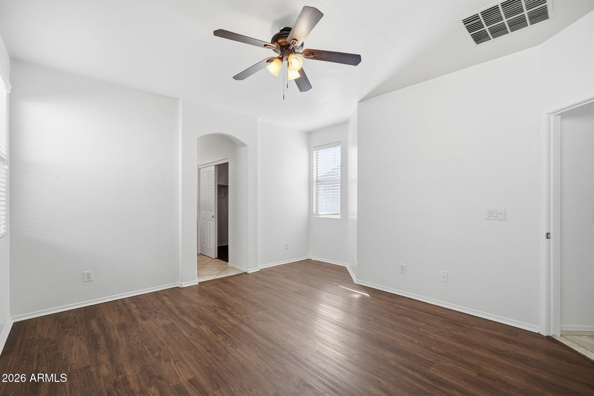 8851 West Payson Road Tolleson, AZ 85353 - Photo 20 of 32 a view of a room with wooden floor and a ceiling fan