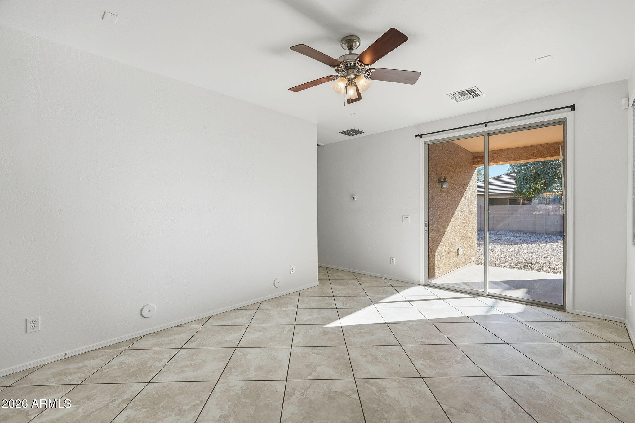 8851 West Payson Road Tolleson, AZ 85353 - Photo 3 of 32 en empty room with window and ceiling fan