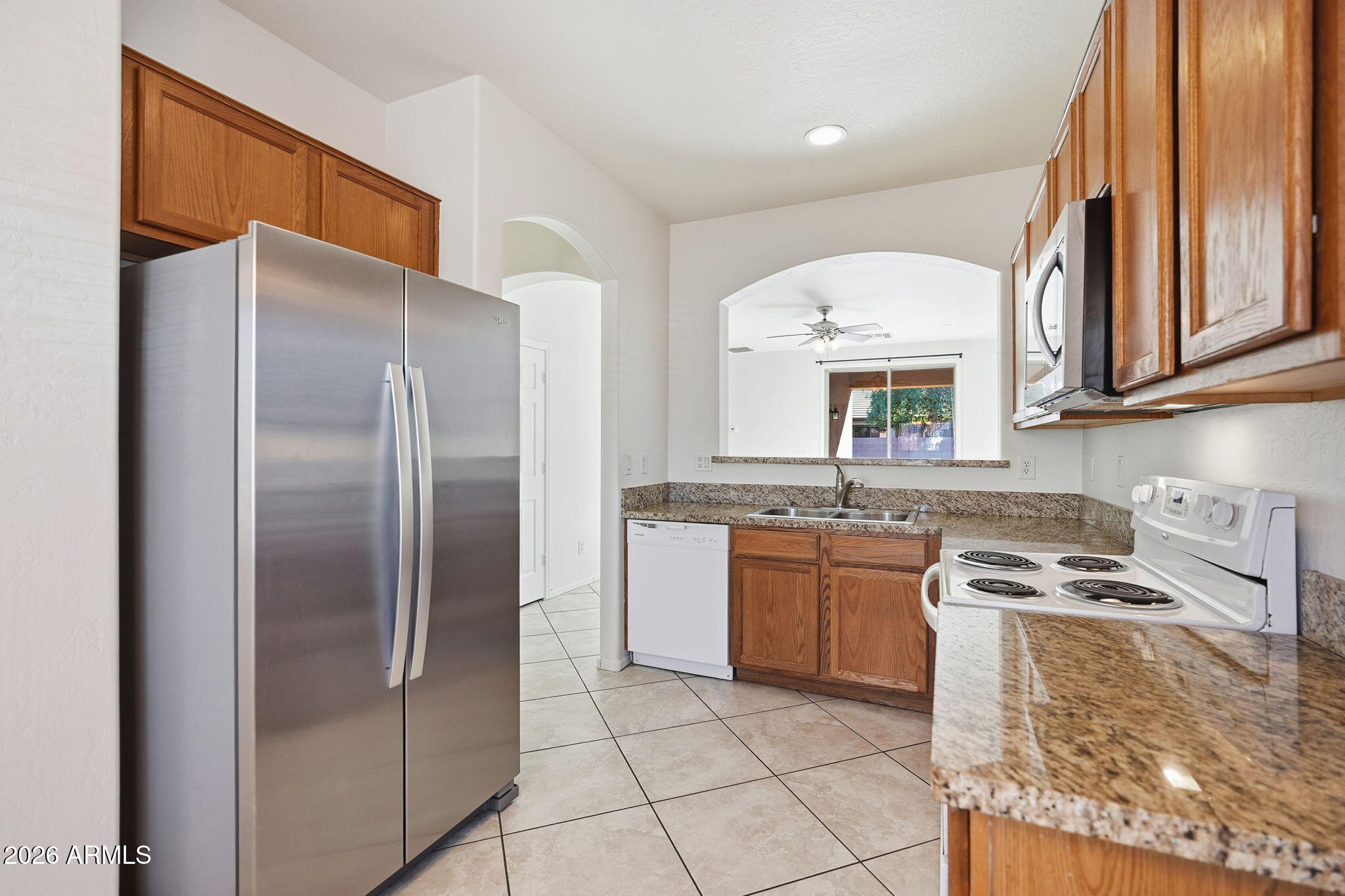 8851 West Payson Road Tolleson, AZ 85353 - Photo 8 of 32 a kitchen with stainless steel appliances granite countertop a refrigerator a stove and a sink