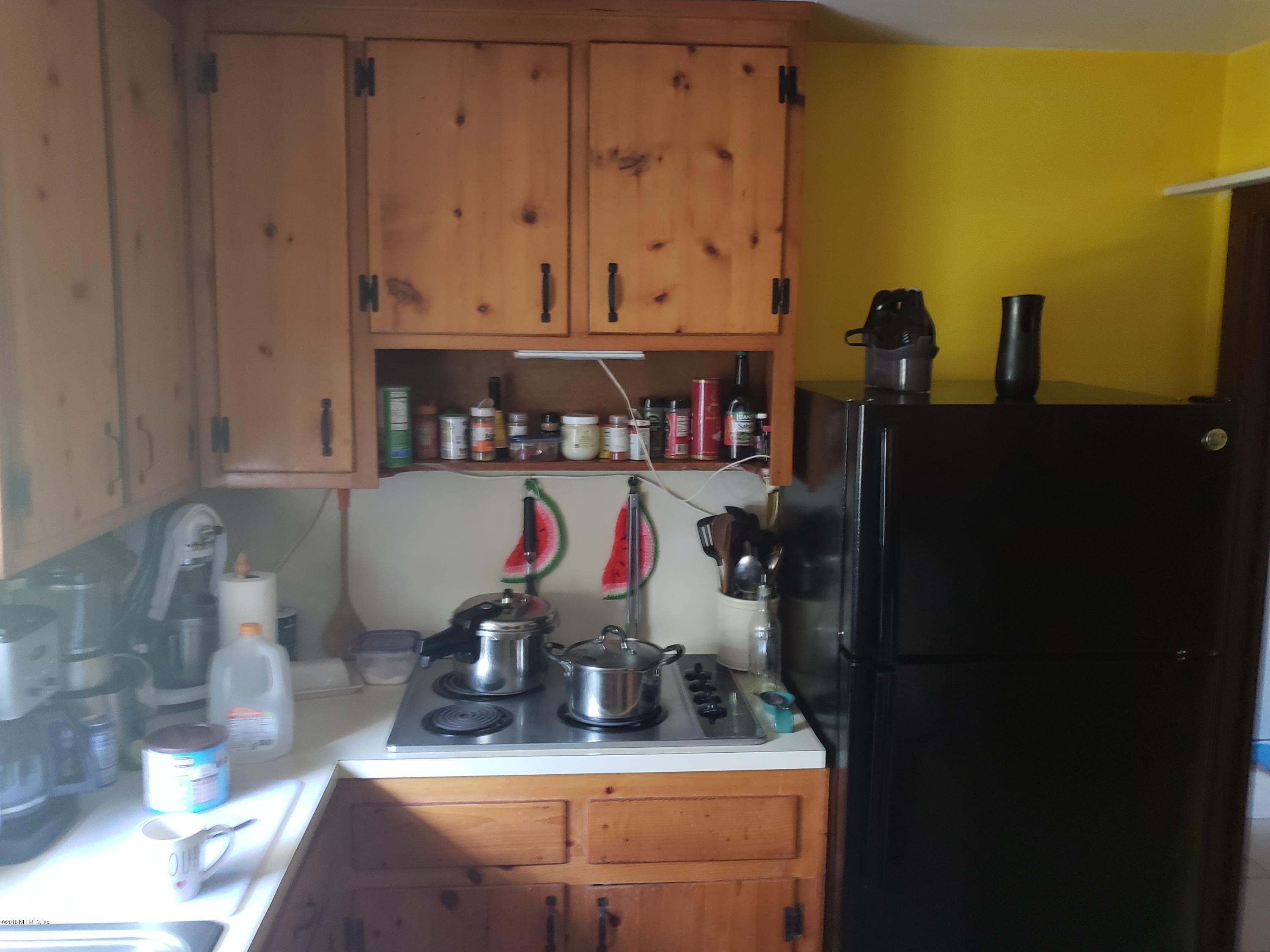 2136 Dean Road Jacksonville, FL 32216 - Photo 6 of 9 a room with water heater and wooden cabinets