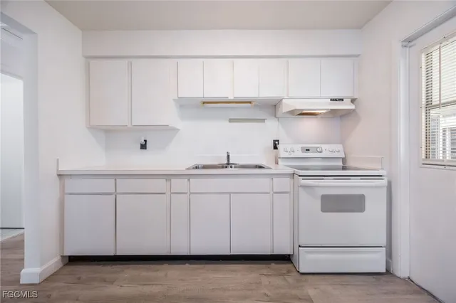 a kitchen with white cabinets and white appliances